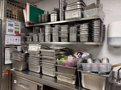many pots and pans on the shelves in the kitchen