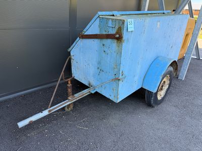une remorque bleue garée devant un immeuble