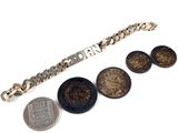 trois pièces et un bracelet sont posés les uns à côté des autres
