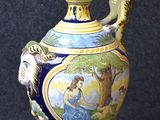 a blue and yellow vase with a bird on top of it