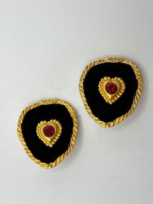 two black and gold heart shaped buttons on a white surface