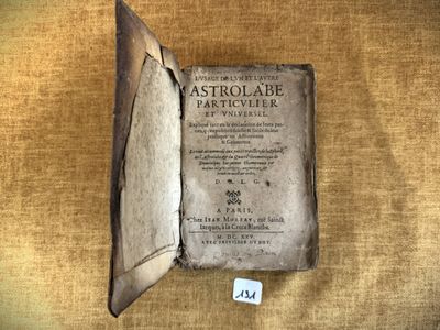 un vieux livre posé sur une table à côté d'une feuille de papier