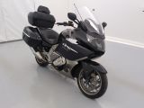 une moto noire garée dans une pièce aux murs blancs