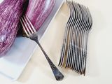 purple eggplant on a white plate with a fork and knife