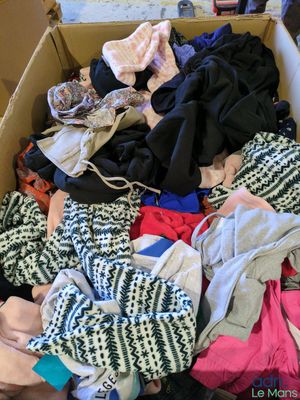 une boîte en carton pleine de vêtements posée sur le sol