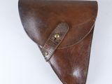étui en cuir marron avec des finitions en laiton sur fond blanc
