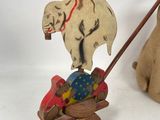 a wooden elephant pulling a cart with a dog on it
