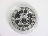 a silver coin with a picture of a plane on it