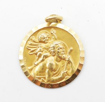 un gros plan sur une médaille d'or représentant Jésus et un enfant