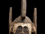 un gros plan d'un masque en bois sur fond noir