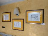 three framed pictures on the wall above a toilet