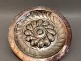un plateau en argent orné d'une fleur, posé sur une table