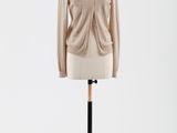 une photo d'un mannequin portant un cardigan beige, posé sur un présentoir