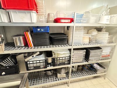 many bins and containers on the shelves in the kitchen