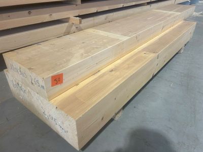 plusieurs pièces de bois sont empilées dans un entrepôt