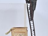 a figurine of a man standing on a ladder next to a book