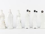 seven figurines of people dressed in white and black