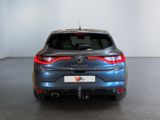 the rear end of a blue car in a room with white walls