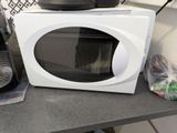 a microwave sitting on a counter with a bag of food in front of it