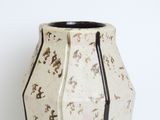 a white vase that has a black stripe on it