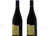 two bottles of wine sitting next to each other on a white surface