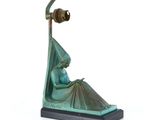 statue d'une femme assise sur un rocher, avec un oiseau sur la tête