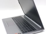 a silver laptop with a black keyboard on a white surface