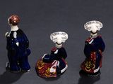 three figurines of people dressed in blue and red standing next to each other