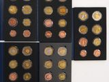 six different types of coins are displayed in a display case