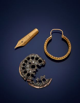 two gold and diamond earrings, a pen, and a piece of jewelry