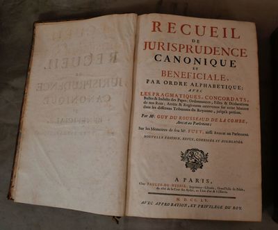 un livre ouvert sur une table, à côté d'un téléphone portable