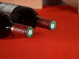 two bottles of wine sitting on a red cloth