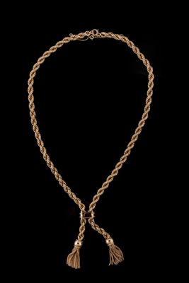 un collier en or orné de pompons sur fond noir