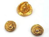 three pieces of gold colored metal on a white surface