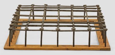 une cage métallique surmontée de poteaux en bois