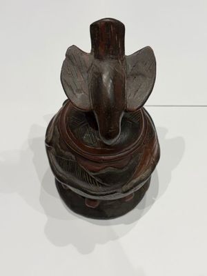 a statue of an elephant sitting on top of a bowl