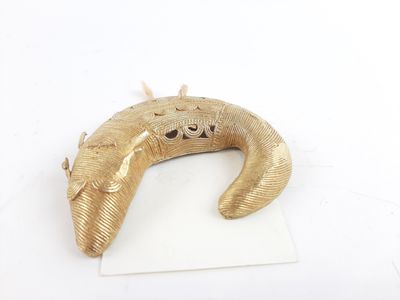 a gold colored horn shaped object on a piece of paper