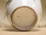 a close up of a white vase with flowers on it