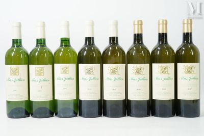 six bouteilles de vin sont alignées sur une surface blanche