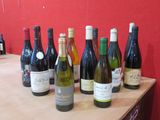 Des bouteilles de vin sont alignées sur une table devant un mur rouge