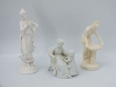 trois figurines blanches représentant des femmes et un homme assis sur une chaise