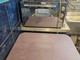 a small table with a pink top in a blue tiled room