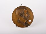 une photo d'une plaque en bronze représentant un homme barbu