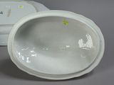 a white bowl with a lid sitting on a table