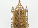an image of a gold metal clock with a cross on it