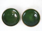 pair of green glazed bowls with gold rims on a white surface