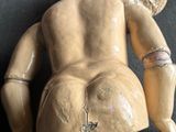 une petite poupée avec un animal en peluche sur le dos