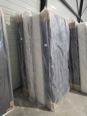 de nombreux matelas empilés les uns à côté des autres dans un entrepôt