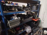 a blue shelf filled with assorted items in a garage