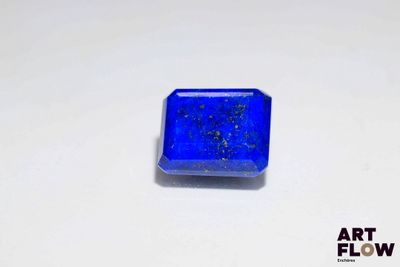 un gros plan d'une pierre bleue de forme carrée posée sur une surface blanche
